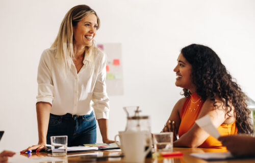 Happy businesswomen having a discussion during a meeting in a creative office. Diverse businesswomen sharing ideas in a boardroom. Group of businesswomen working together in an all-female startup.