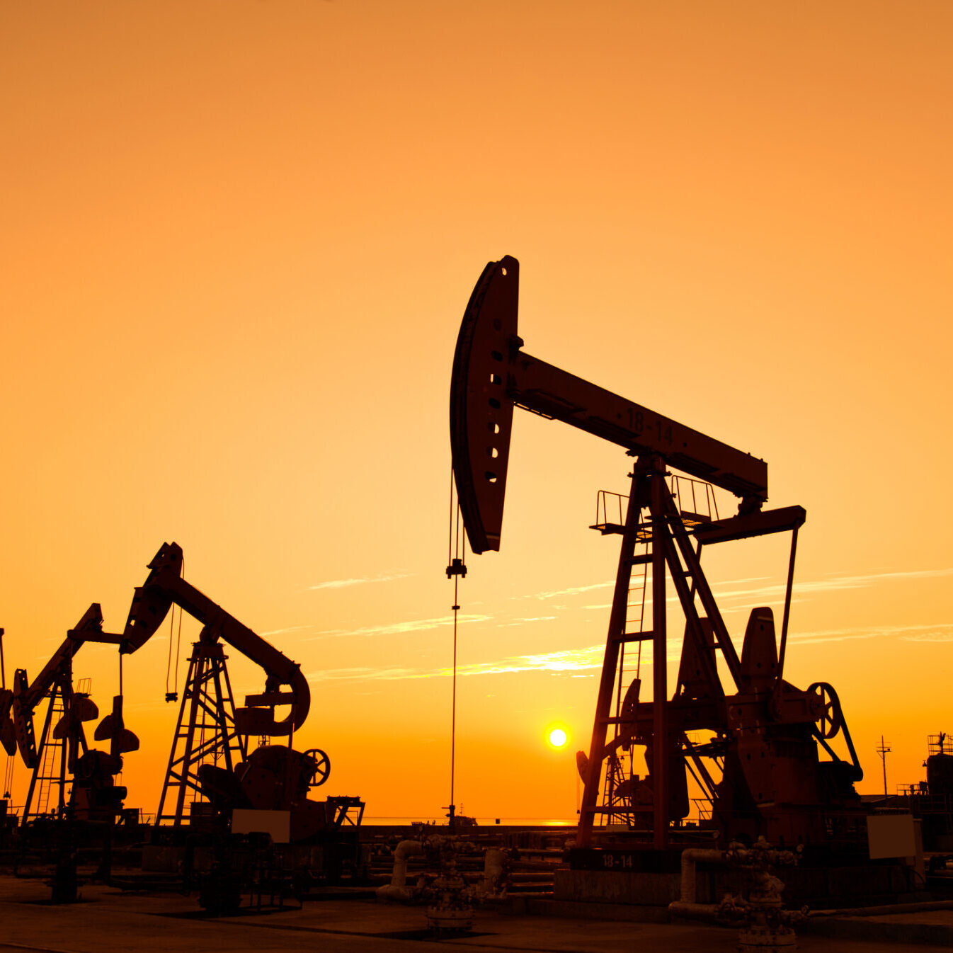 Oil pumps and rig at sunset Oil pumps and rig at sunset