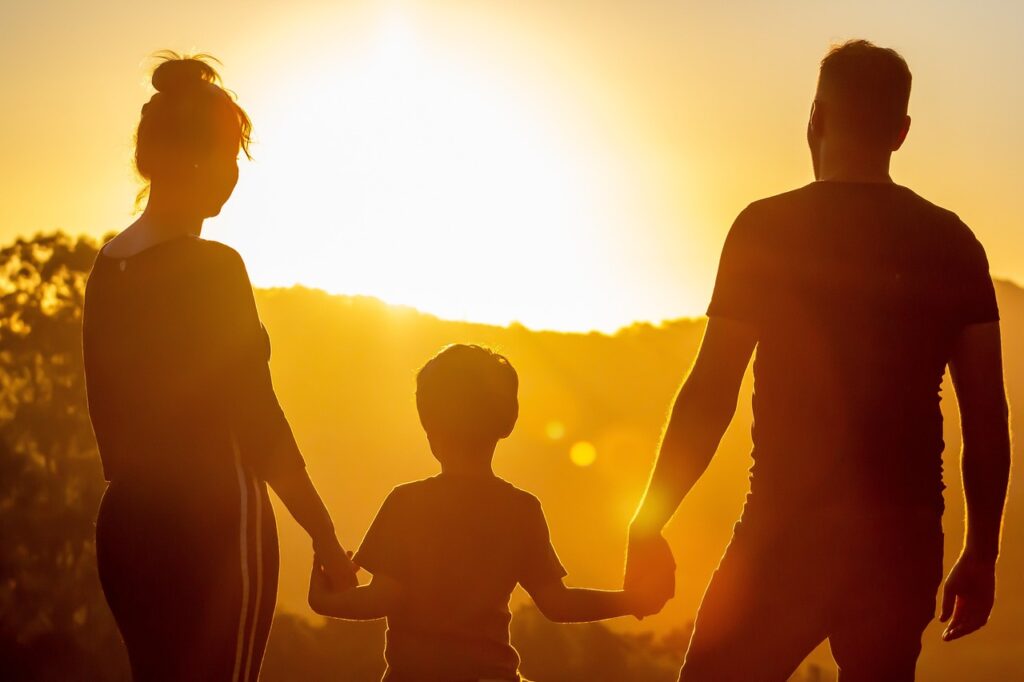 A picture of parents and their child looking at the sunset