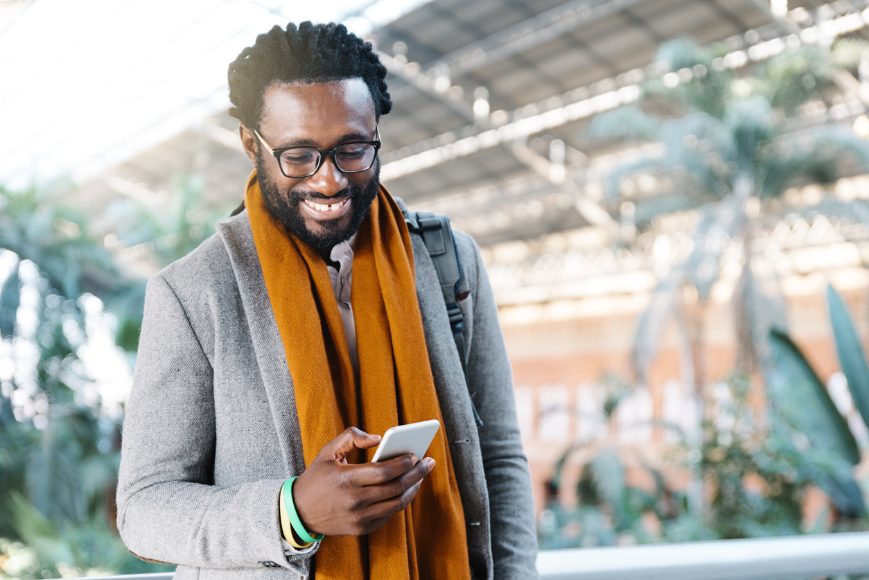Man smiling while looking at his phone